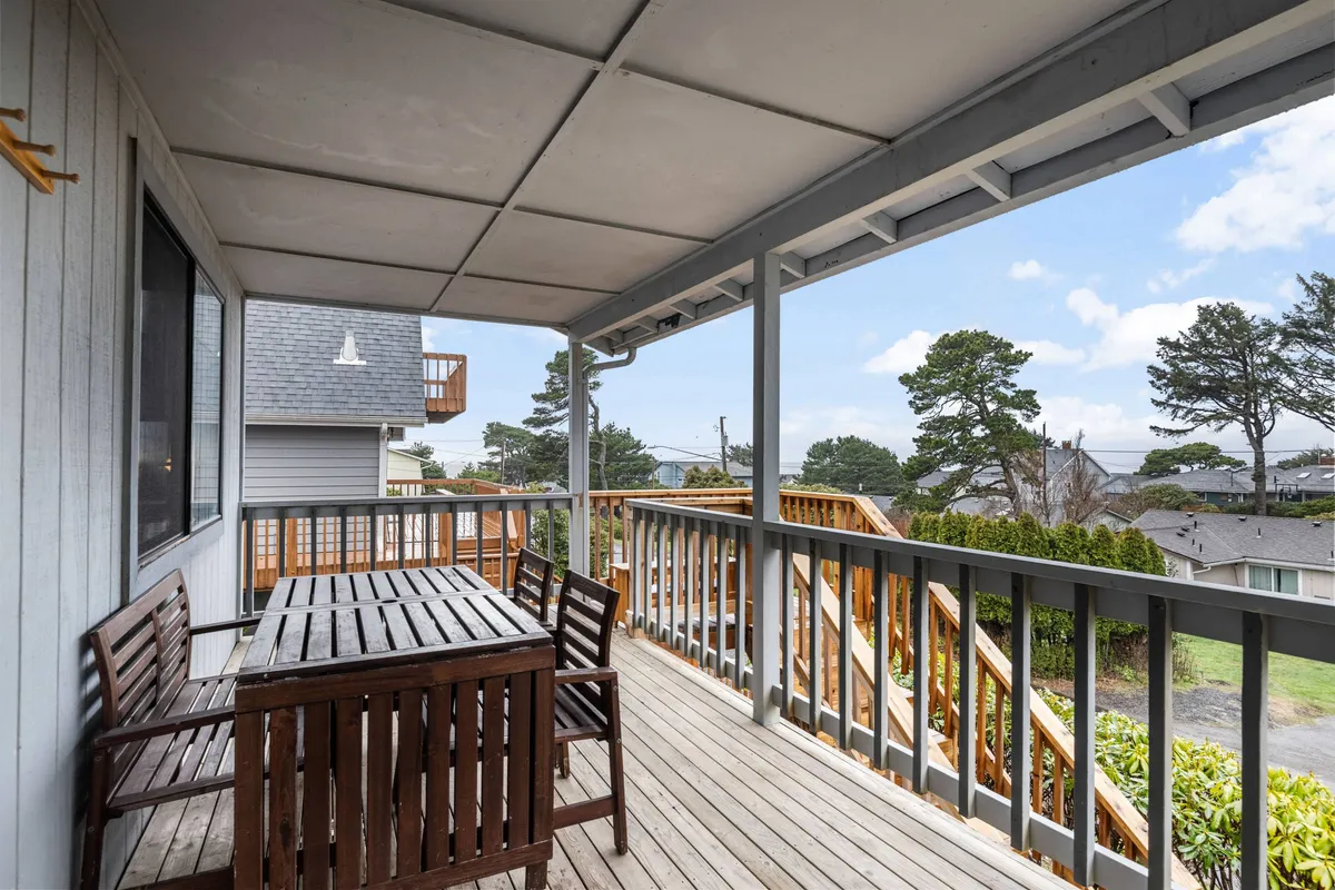 An inviting exterior space featuring a wooden dining table surrounded by greenery and open sky. The relaxed ambiance is perfect for enjoying morning coffee or sunset gatherings.