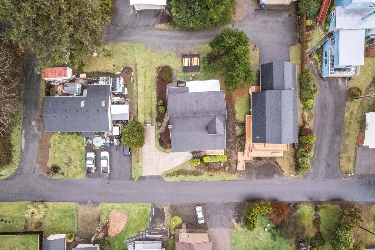 This exterior image features residential homes, visible driveways, and landscaped gardens. The driveways are clearly defined, providing a sense of privacy and ample parking space for multiple vehicles.
